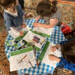 Small children color an activity sheet.