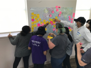 Community members place sticky notes onto a map to show assets and organizations that provide community services in Boston neighborhoods