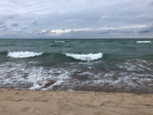 Waves hitting a sandy shoreline on a cloudy day at Warren Dunes, Lake Michigan