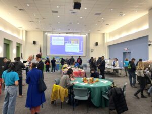 A room full of people talking at different stations
