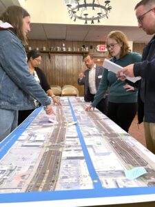 People talking over a roll plot showing Spring Garden Street