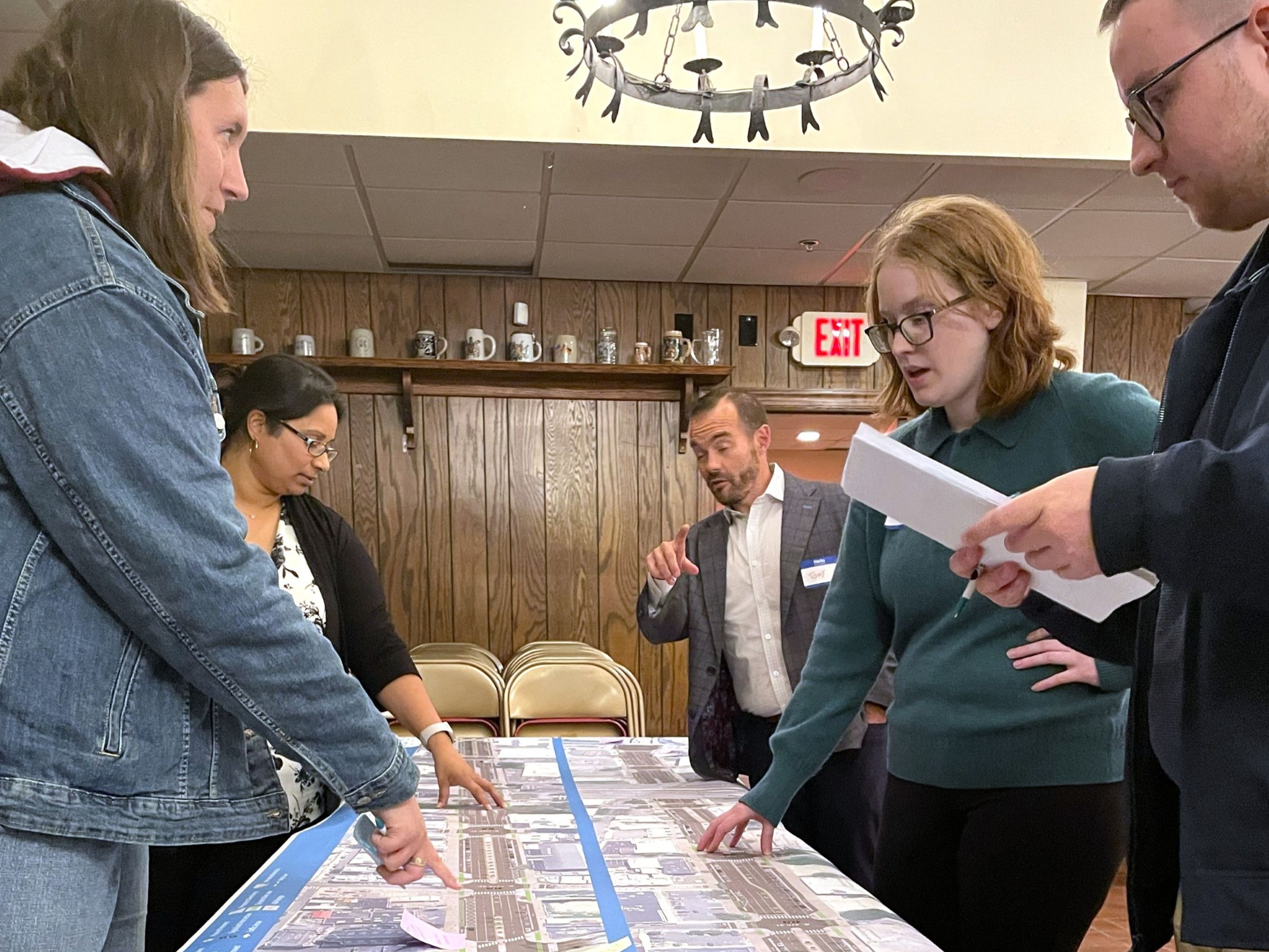 People talking over a roll plot showing Spring Garden Street
